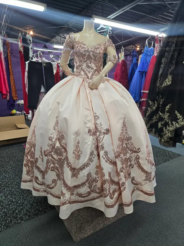 Vestido de quinceañera marfil y oro rosa en la boutique